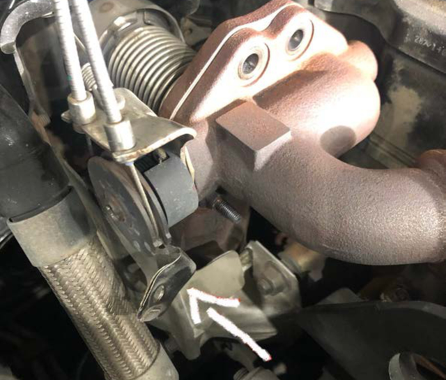 Pry the heat shield off its stud and bend it out of the way