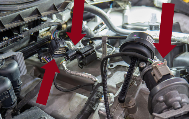 Unplug the harnesses on top of the EGR cooler and the vacuum hose